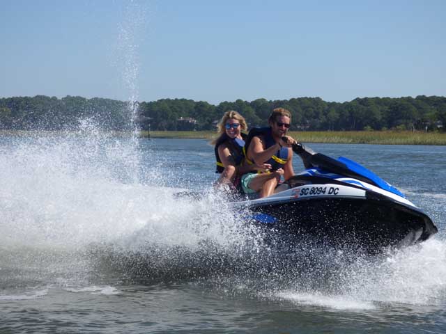 JetSkisatIslandHeadWatersports Two people on a speeding jet ski