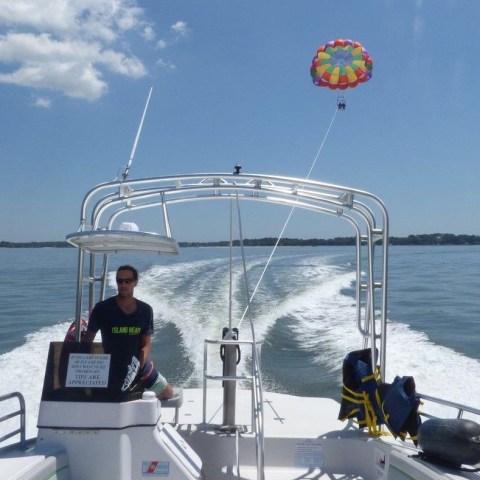A boat pulling a rainbow parasail