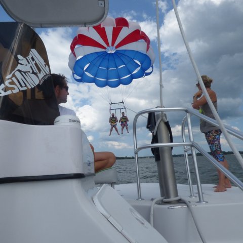 A red white and blue parasail over an Island Head boat