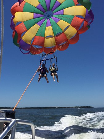 photo0jpg A rainbow parasail hovering over water behind a boat